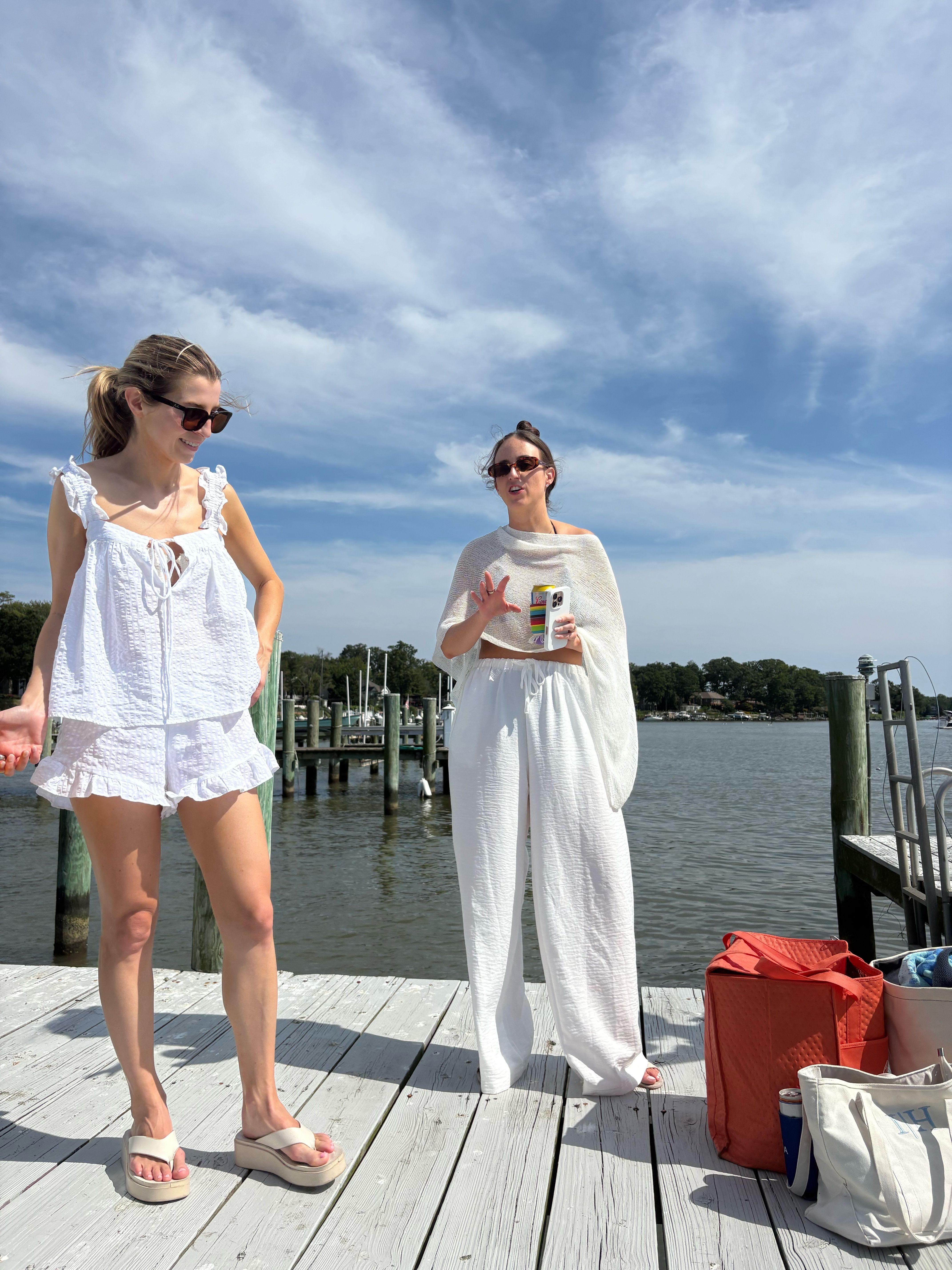 Two women on the wooden dock, bags at their feet