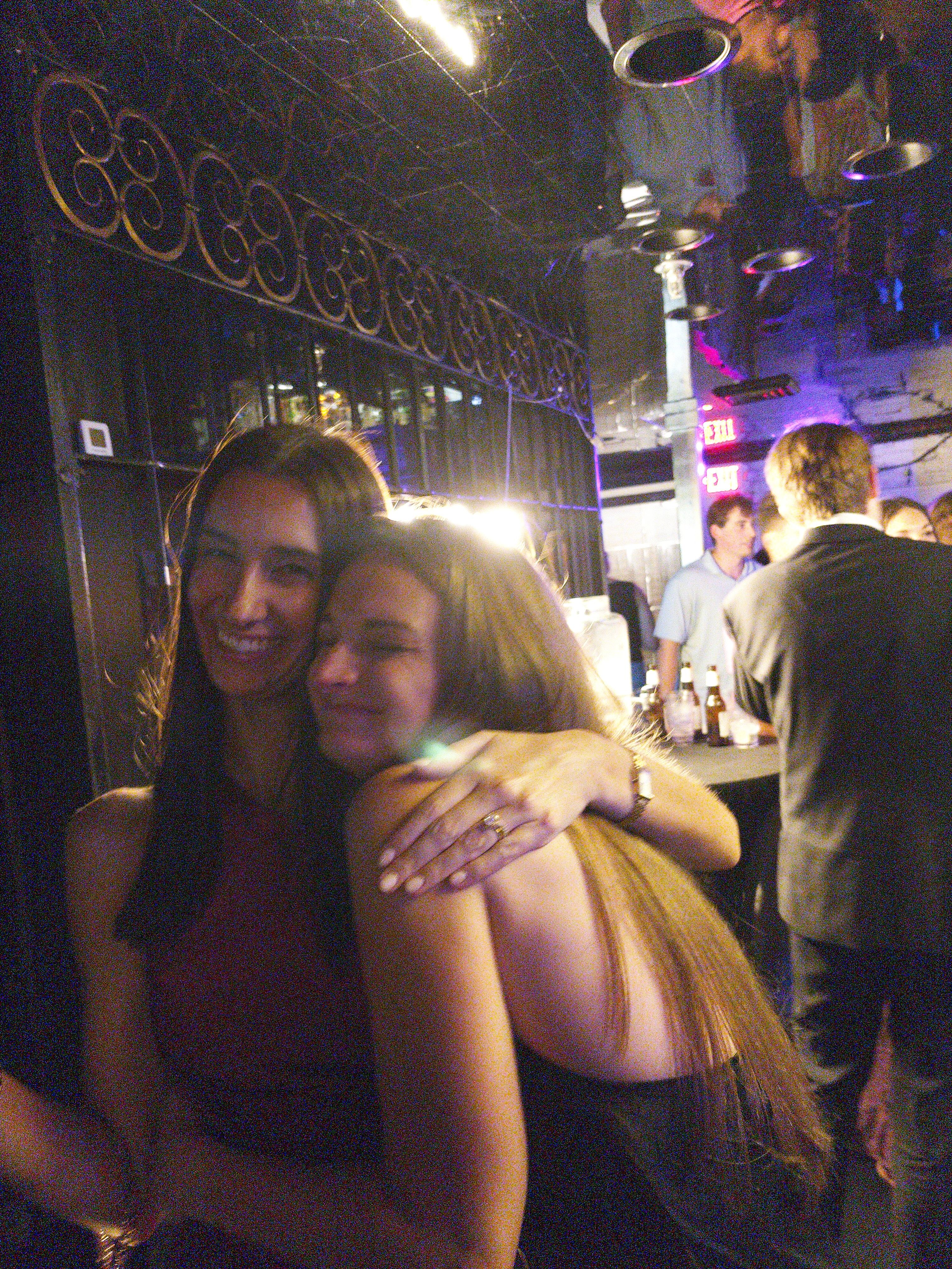 Two women hugging, candid, dark hair