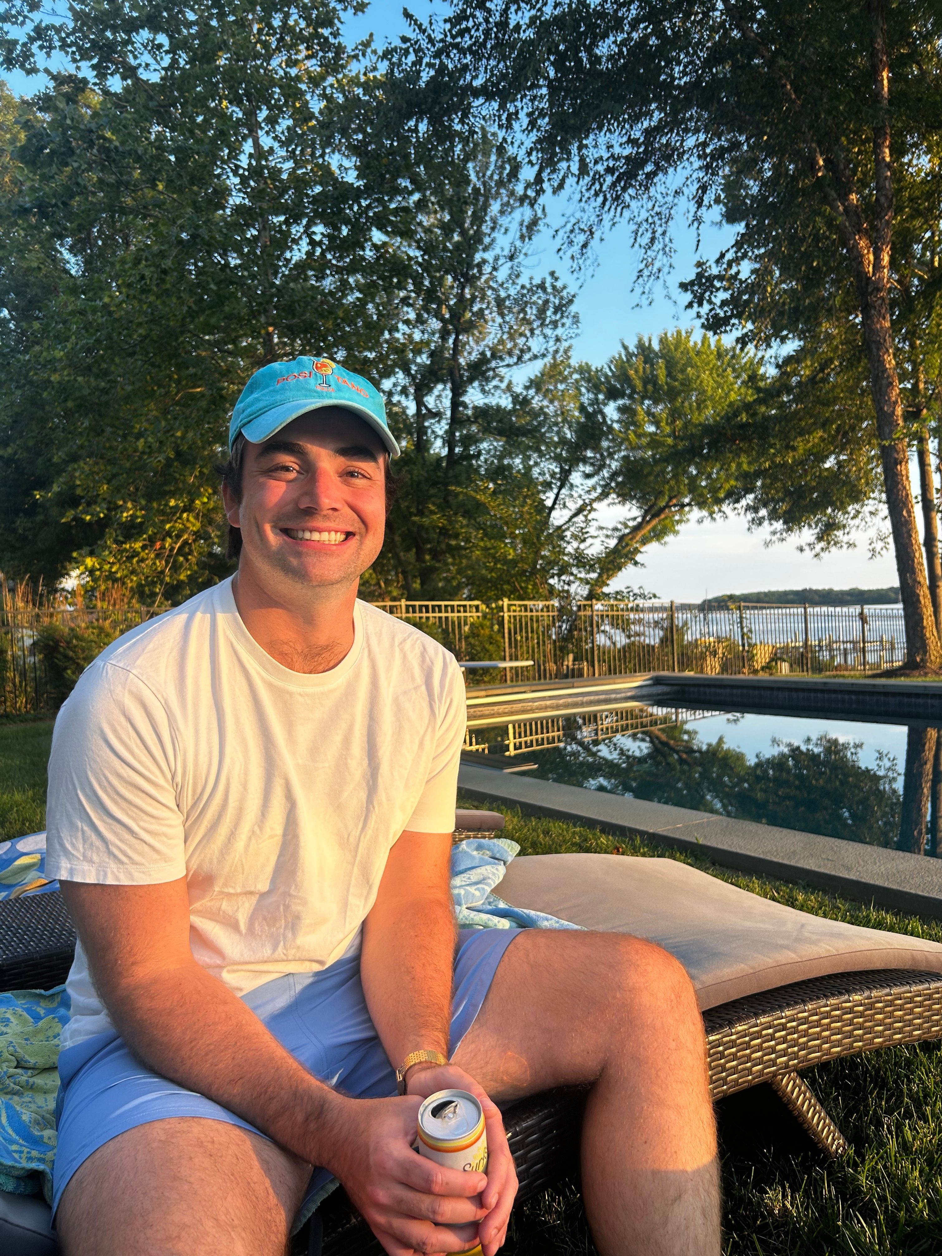 Sitting by the pool at golden hour, river behind the fence